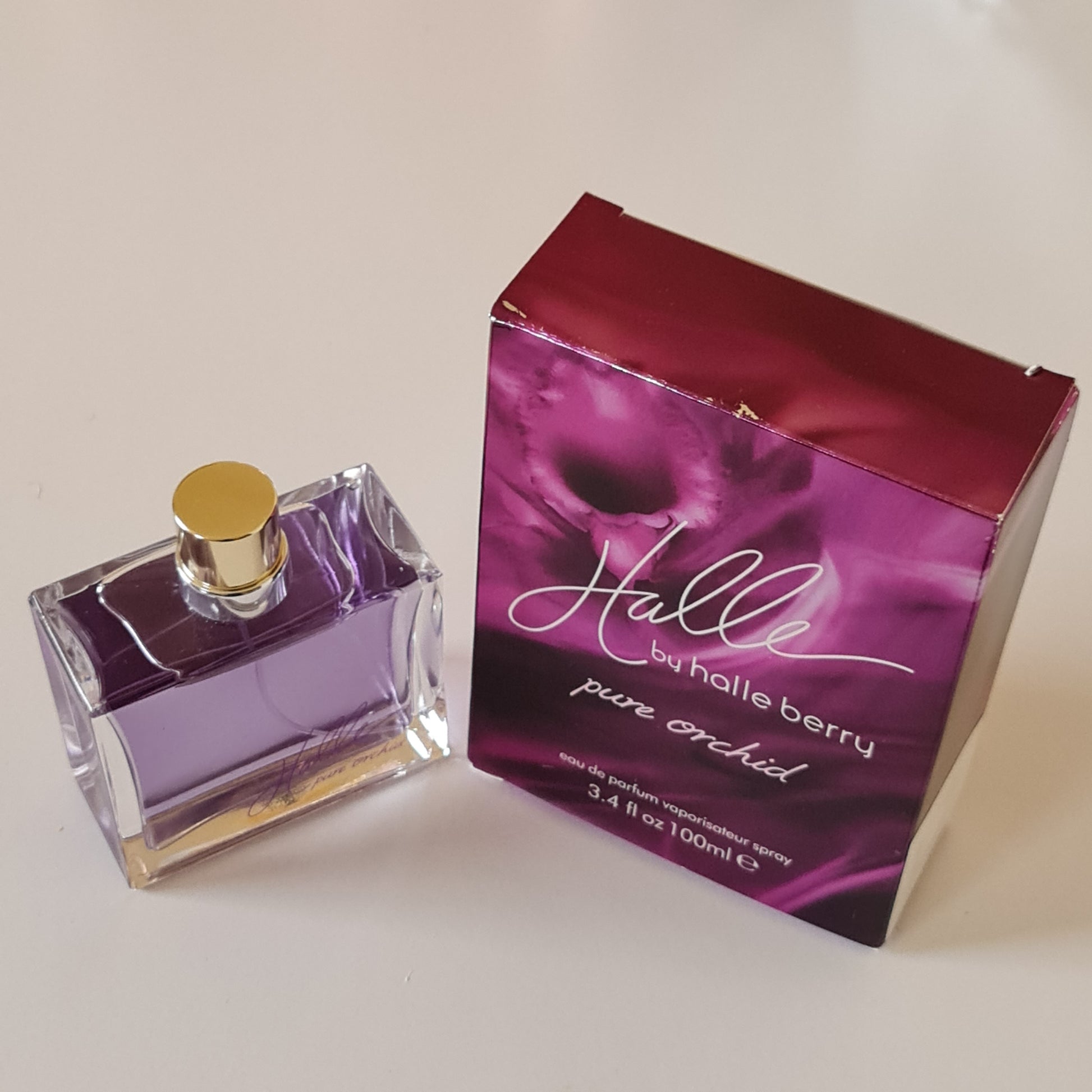 Halle Berry Pure Orchid Eau de Parfum 100ml. Front angled photo box and bottle, fragrance, perfume, cologne and scent.